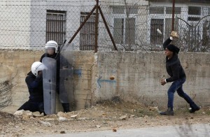A Palestinian youth throws a stone at policemen outside the Jalazoun refugee camp near the West Bank city of Ramallah on Jan. 12.  /LENS/Mohamad Torokman
