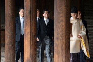 A Shinto priest leads Japanese Prime Minister Shinzo Abe as he visits the Yasukuni Shrine in Tokyo on Dec. 26.  /AFP/Toru Yamanaka