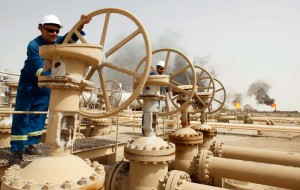 Workers adjust oil pipe valves in Iraq's Zubair oil field.  /Reuters