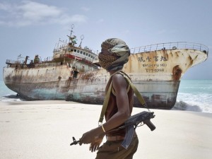 Sept. 23, 2012, masked Somali pirate Abdi Ali walks past a Taiwanese fishing vessel that washed up on shore after the pirates were paid a ransom and released the crew.  /AP