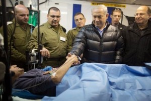 Israeli Prime Minister Benjamin Netanyahu and Defense Minister Moshe Ya'alon, right, visit an injured Syrian rebel fighter.