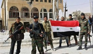 Syrian regime forces hold the Syrian flag as they pose for a photo in the village of al-Sahel, near the rebel held town of Yabrud, nearly 80 kilometrers north of Damascus, on March 4.