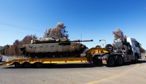 A truck carries an Israeli Merkava tank making its way to the Israeli-Syrian border in the center of the Golan Heights.  /EPA