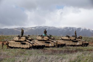 Israeli soldiers stand atop tanks in the Golan Heights near Israel's border with Syria.  /Reuters/Ronen Zvulun