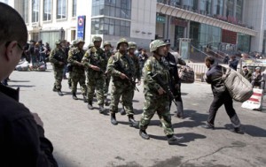 Heavily armed Chinese paramilitary police march past the site of the April 30 explosion outside the Urumqi South Railway Station.  /AP/Ng Han Guan