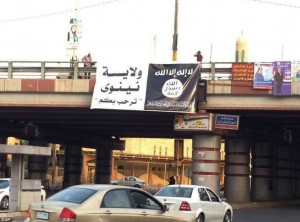 An image posted on a militant Twitter account today appears to show a banner bearing a black flag used by the Al-Qaeda inspired lslamic State of Iraq and the Levant (ISIL) hanging from an overpass in Mosul, Iraq.  /AP