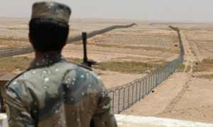 A member of the Saudi Border Guards stands guard next to a fence on Saudi Arabia's northern borderline with Iraq on July 14.  /Faisal Nasser/Reuters