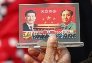 A Tiananmen Square street vendor displays a souvenir with pictures of Chinese President Xi Jinping and Chairman Mao Zedong.