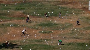 Palestinians gather leaflets that fell from an Israeli plane on July 30.  /Hatem Moussa/AP
