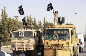 Militant Islamist fighters wave flags as they take part in a military parade in Syria's northern Raqqa province.