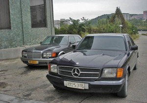 Luxury cars parked in front of a Pyongyang hotel.