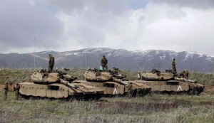 Israeli soldiers stand atop tanks in the Golan Heights near Israel's border with Syria.  /Reuters