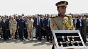 Egypt's President Abdel-Fattah el-Sisi, far left, and other officials follow a soldier carrying medals of troops killed in Friday's attack in the Sinai Peninsula. / AP / MENA)