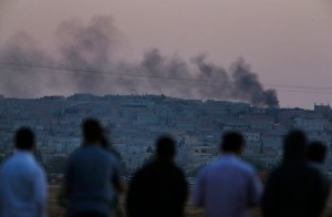 Kurds in Suruc, Turkey look on as ISIL presses its assault across the border in Kobani, Syria.  /Lefteris Pitarakis/AP
