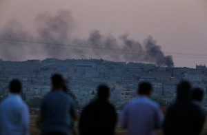 Kurds in Suruc, Turkey look on as ISIL presses its assault across the border in Kobani, Syria. /Lefteris Pitarakis/AP