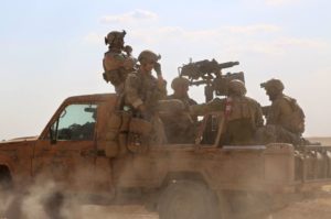 Armed men in uniform identified by Syrian Democratic forces as US special operations forces ride in a pickup truck in the village of Fatisah, in the northern Syrian province of Raqa on May 25. /AFP/Delil Souleiman