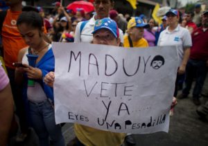 A woman holds a sign with a message that reads in Spanish: “Maduro leave already……you are a nightmare!” during an opposition march in Caracas on May 14. /AP/Ariana Cubillos
