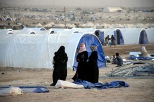 Displaced women wait for their tent to be built at a refugee camp west of Baghdad on June 21. /Nawras Aamer/EPA