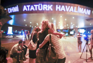 Passengers embrace each other at the entrance of Istanbul's Ataturk airport, early Wednesday, following their evacuation after a blast. /AP
