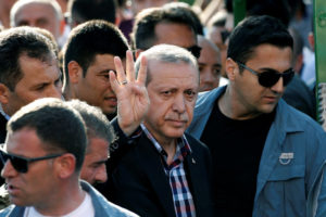 Turkish President Recep Tayyip Erdogan gives a four-finger gesture of solidarity with the Muslim Brotherhood during a funeral for a casualty of the thwarted coup. /Reuters