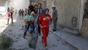 Residents run for cover after a Syrian regime airstrike in Aleppo. /AFP
