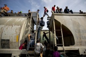 Central American migrants climb on a north bound train during their journey toward the U.S.-Mexico border. /AP